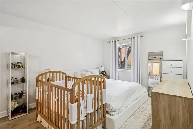 a bedroom with a bed and wooden floor