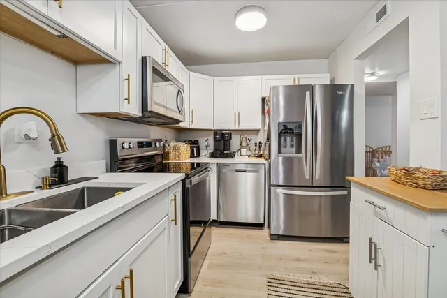 a kitchen with white cabinets and stainless steel appliances