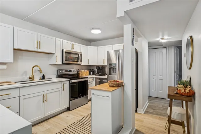 a kitchen with stainless steel appliances a refrigerator sink and cabinets