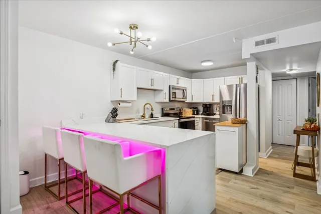 a kitchen with a dining table chairs and refrigerator