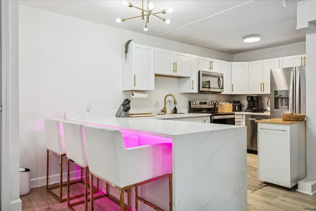 a kitchen with kitchen island granite countertop a sink cabinets and wooden floor