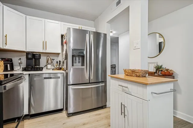 a kitchen with kitchen island granite countertop appliances cabinets and a sink