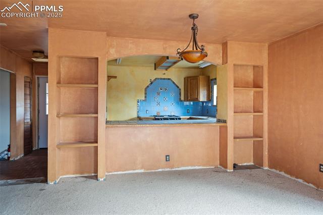 4775 Meridian Road Peyton, CO 80831 - Photo 10 of 25 Kitchen with built in features, tile countertops, carpet floors, and decorative light fixtures