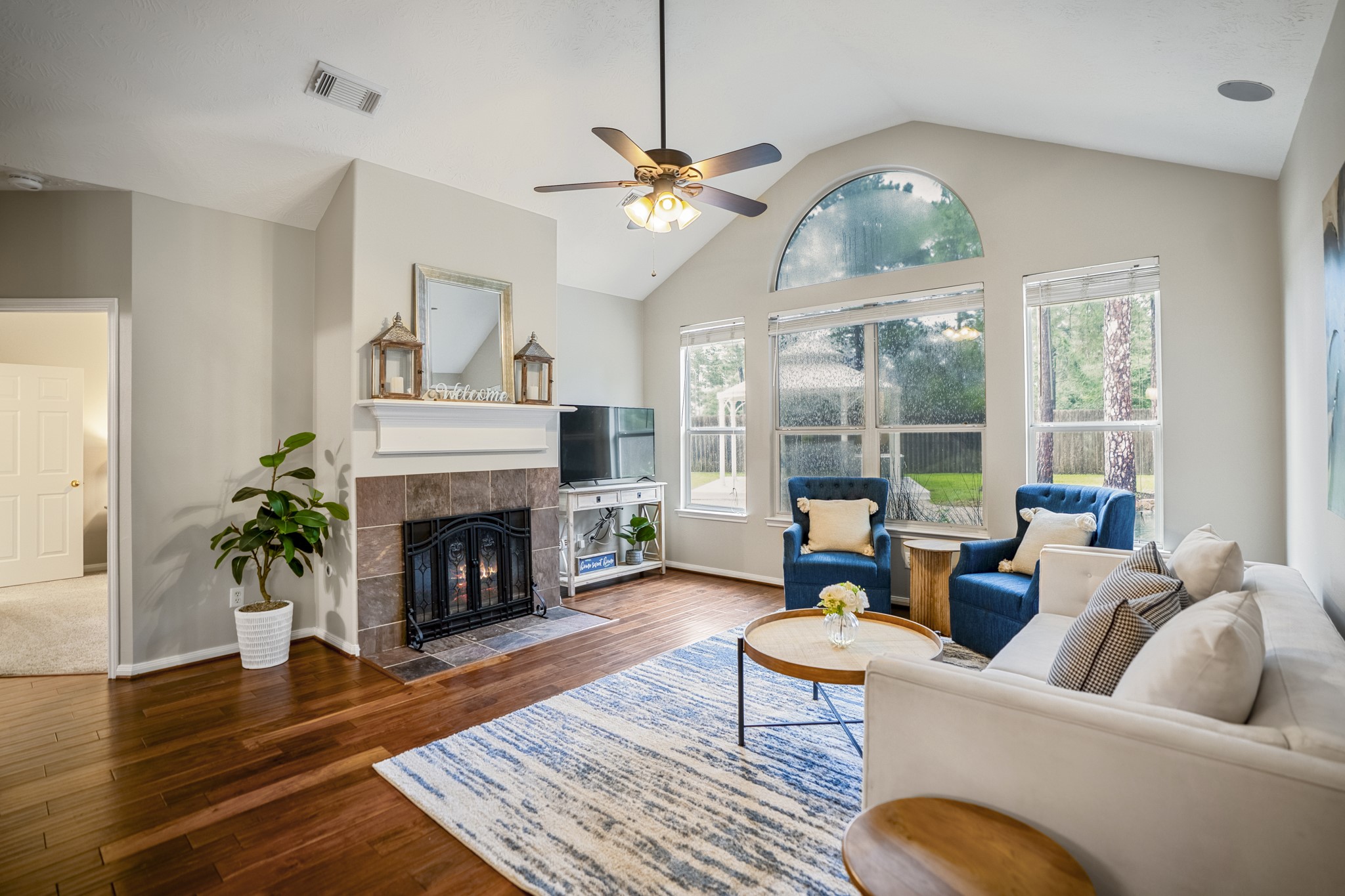 6311 Sparrows Glen Lane Spring, TX 77379 - Photo 13 of 50 Vaulted ceilings give the living room an airy feel, while the gas-log fireplace provides a cozy space to enjoy, and tall windows frame the pool and gazebo just outside.