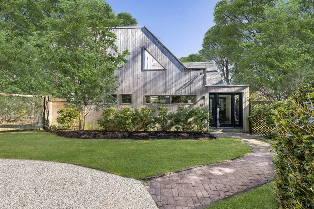 a front view of a house with a yard and trees