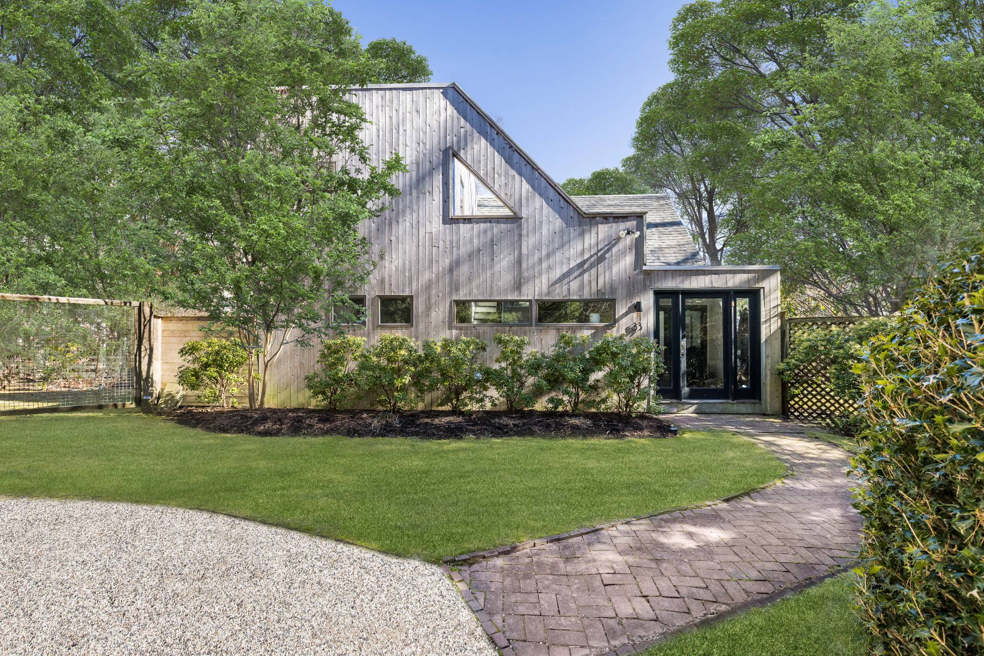 a front view of a house with a yard and trees