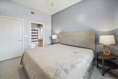 a large bed sitting in a bedroom next to a lamp and a closet