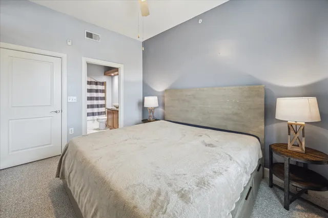 a large bed sitting in a bedroom next to a lamp and a closet