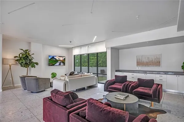 a living room with furniture potted plant and windows