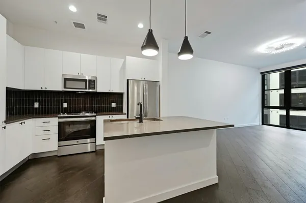 a kitchen with stainless steel appliances a stove a sink and a refrigerator