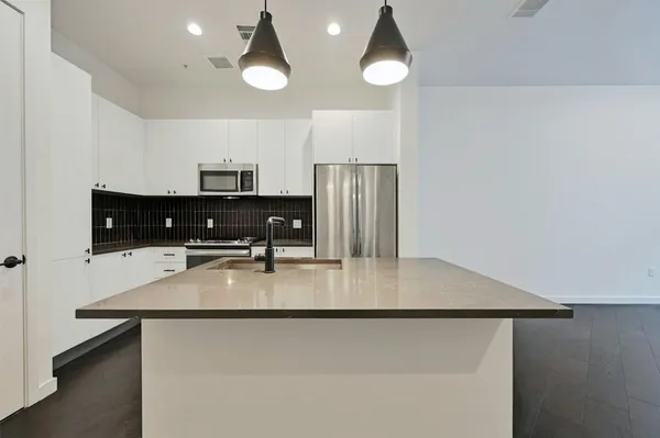a kitchen with stainless steel appliances a refrigerator a stove a microwave and island