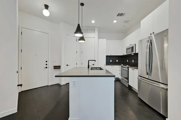 a kitchen with stainless steel appliances a sink stove and refrigerator