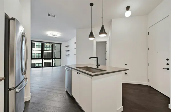 a kitchen with stainless steel appliances granite countertop a sink a window and a refrigerator