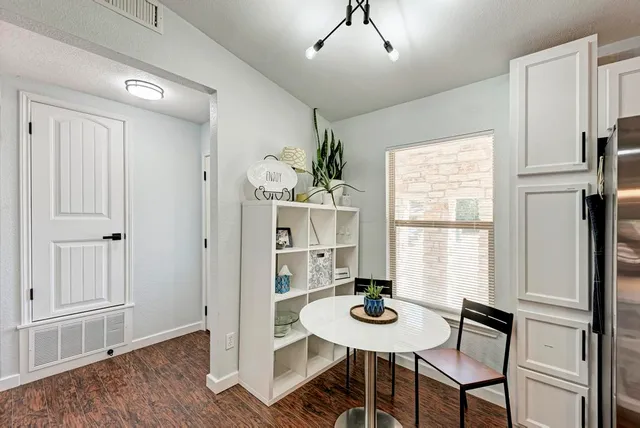 a kitchen with white cabinets and refrigerator