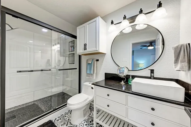 a bedroom with a bed a chandelier and dresser