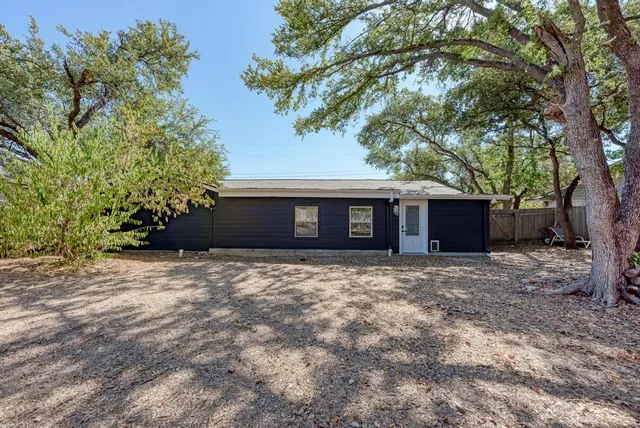 a view of a yard with plants and trees