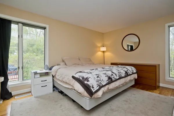a bedroom with a bed a large window and a chandelier