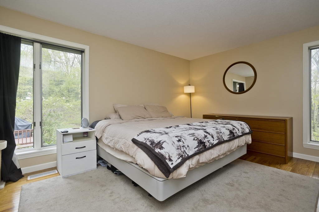 32 Zuell Hill Road Monson, MA 01057 - Photo 19 of 37 a bedroom with a bed a large window and a chandelier