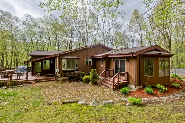 a view of a house with wooden deck and furniture