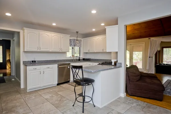 a kitchen with kitchen island granite countertop a stove a sink a refrigerator and cabinets