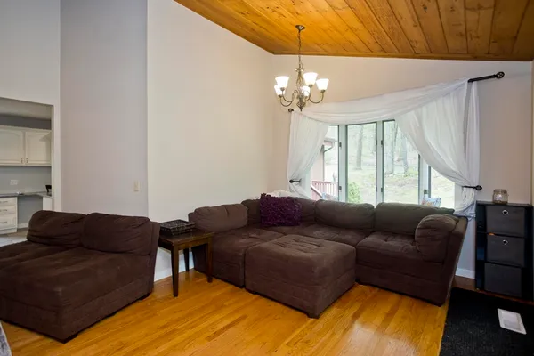 a living room with furniture a chandelier and a dining table