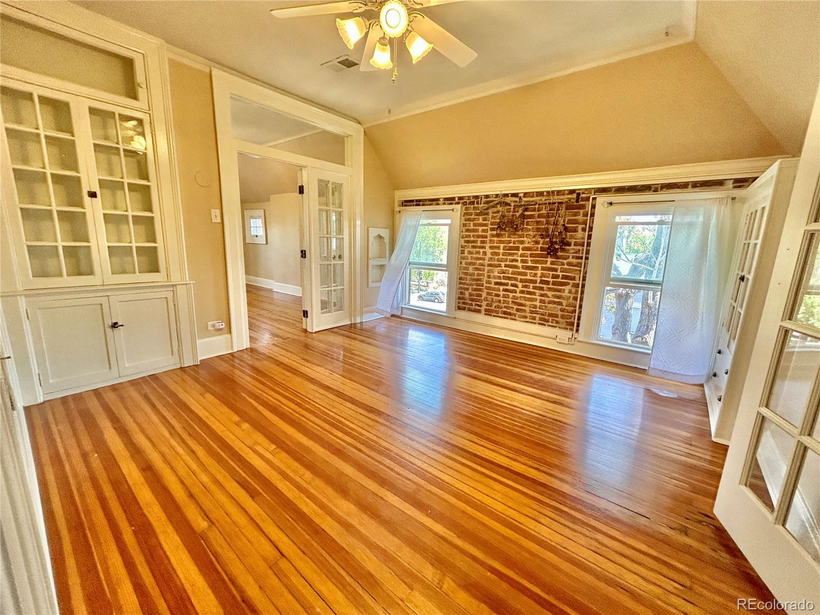 16-th 16-th E 16th Denver, CO 80203 - Photo 14 of 38 a view of an empty room with wooden floor and a window