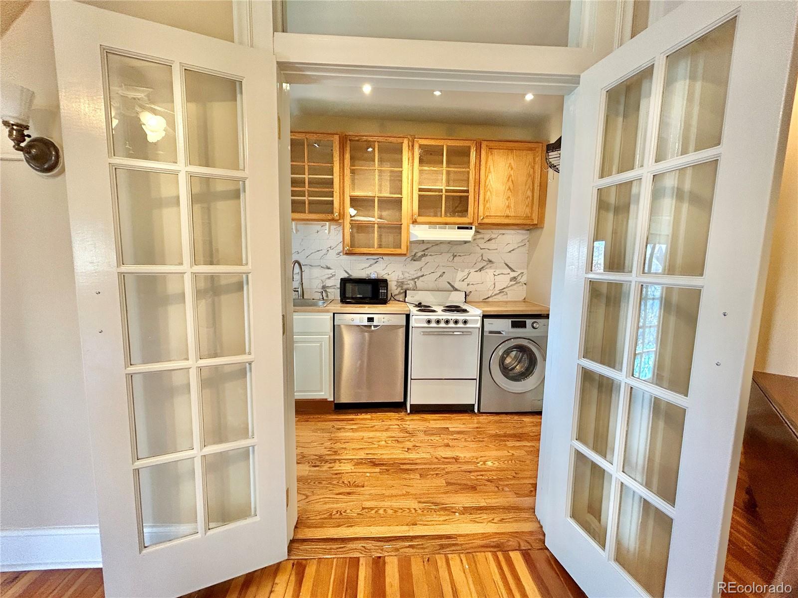 16-th 16-th E 16th Denver, CO 80203 - Photo 19 of 38 a view of a kitchen with an empty space and wooden floor