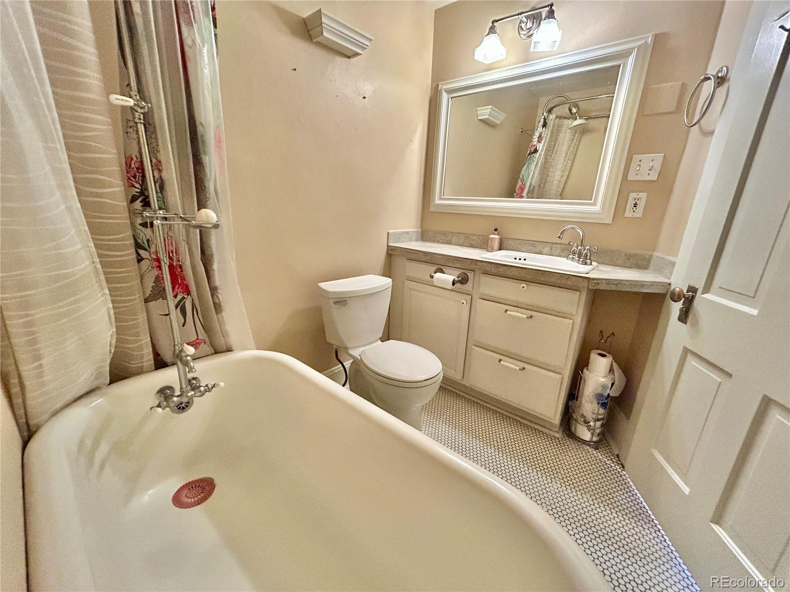 16-th 16-th E 16th Denver, CO 80203 - Photo 23 of 38 a bathroom with a sink a toilet and a mirror