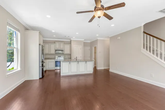 a view of an empty room and window with wooden floor