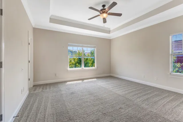 an empty room with windows and fan