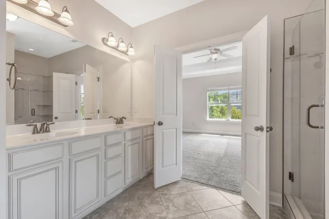 a spacious bathroom with a shower sink and mirror