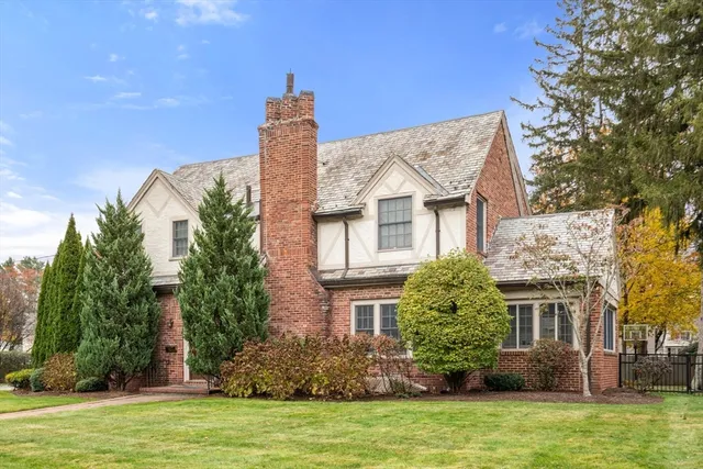 a front view of a house with a garden and plants