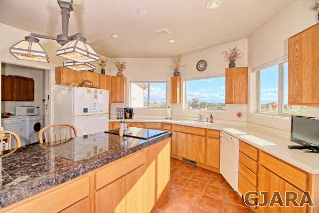1701 O Road Fruita, CO 81521 - Photo 9 of 23 a large kitchen with granite countertop a sink and a stove top oven