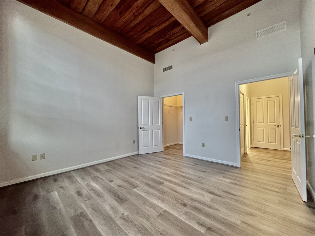 4 Bishop Street, Unit 206 Framingham, MA 01702 - Photo 12 of 28 a view of an empty room with wooden floor and a window