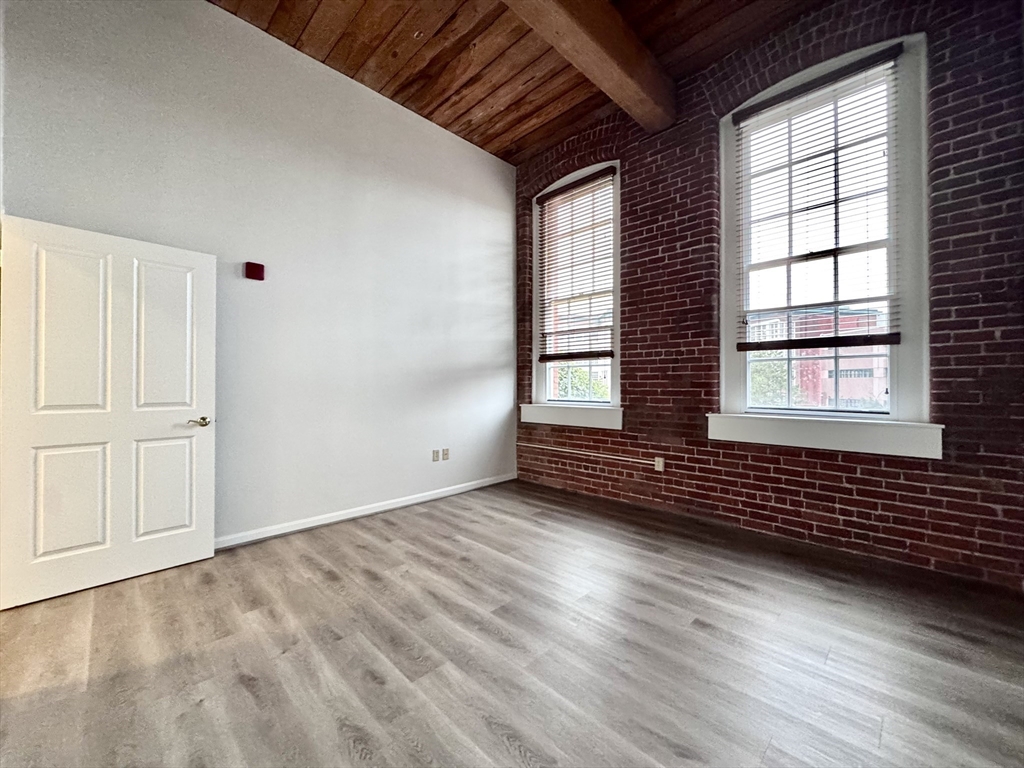 4 Bishop Street, Unit 206 Framingham, MA 01702 - Photo 14 of 28 a view of an empty room with wooden floor and fan