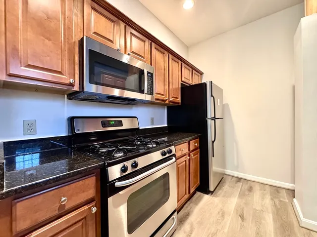 a kitchen with stainless steel appliances granite countertop a stove and a microwave