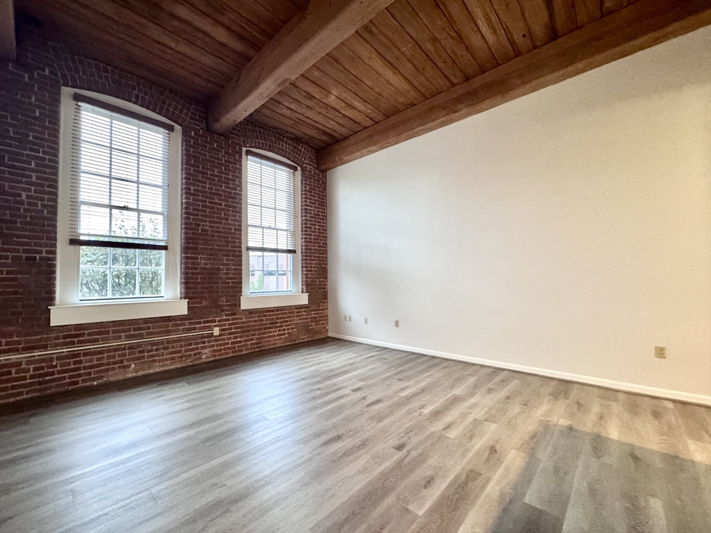 4 Bishop Street, Unit 206 Framingham, MA 01702 - Photo 8 of 28 an empty room with wooden floor and windows