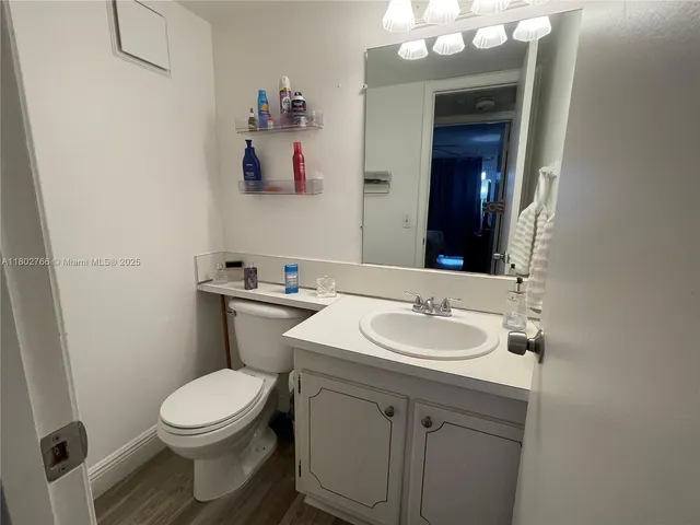 a bathroom with a sink vanity mirror and toilet
