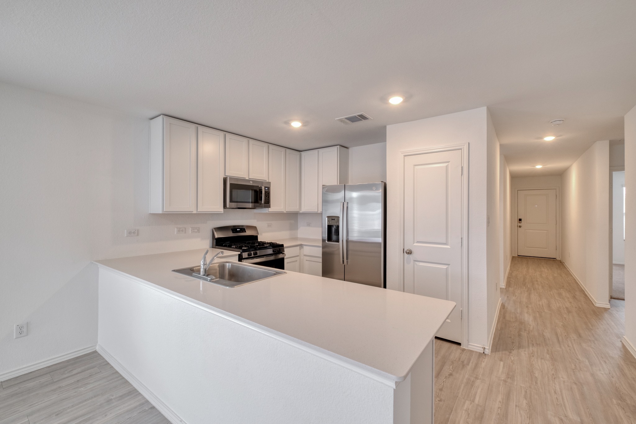 23412 Tiny Moons Way Elgin, TX 78621 - Photo 7 of 38 Kitchen featuring white cabinetry, stainless steel appliances, a gas range, and a breakfast bar with an undermount sink