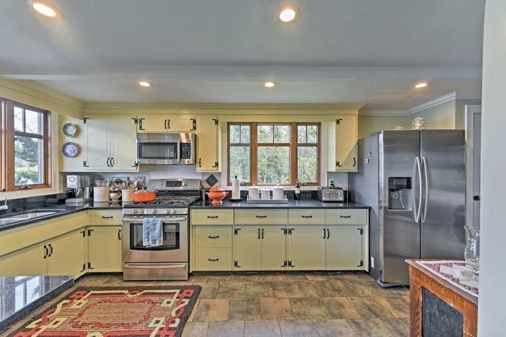232 Lagoon Pond Road Tisbury, MA 02568 - Photo 14 of 31 a kitchen with stainless steel appliances granite countertop a sink a stove a refrigerator cabinets and a window