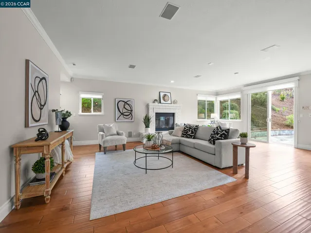 an empty room with wooden floor window and ceiling fan
