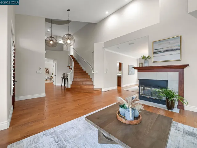 a view of a dining room and livingroom with furniture wooden floor a rug a chandelier