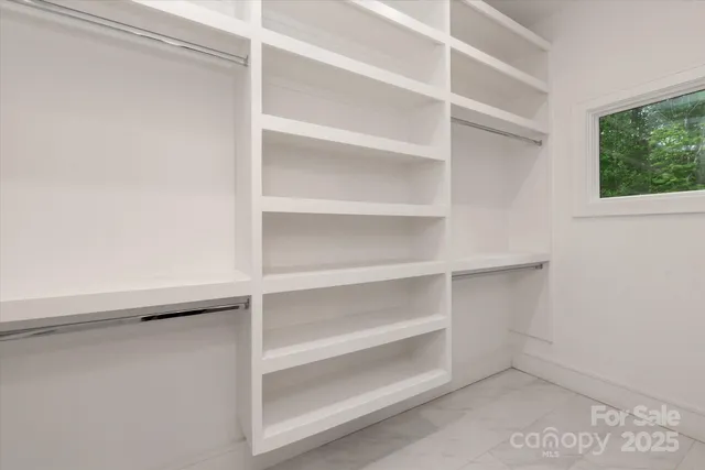 a view of walk in closet with empty racks