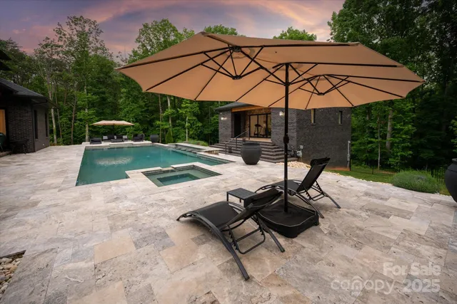 a view of patio with chairs and table under an umbrella