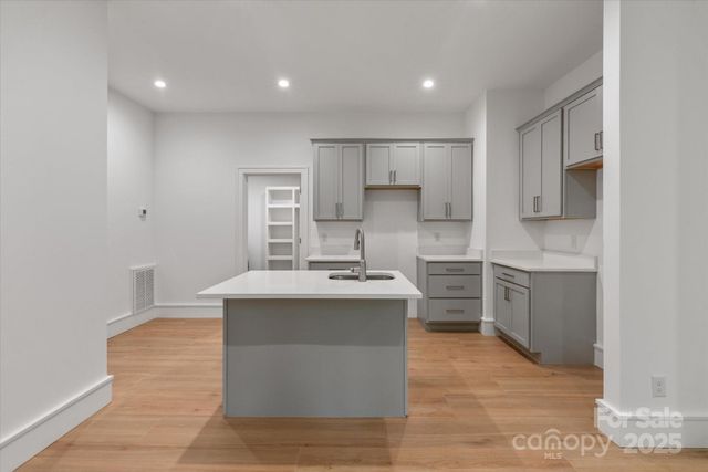 a large kitchen with kitchen island a sink a stove and a refrigerator
