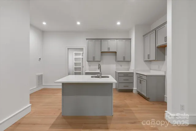 a large kitchen with kitchen island a sink a stove and a refrigerator