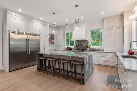 a kitchen with stainless steel appliances granite countertop a kitchen island hardwood floor sink stove and refrigerator