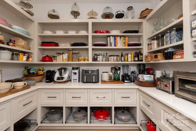 a kitchen with white cabinets and wooden floor