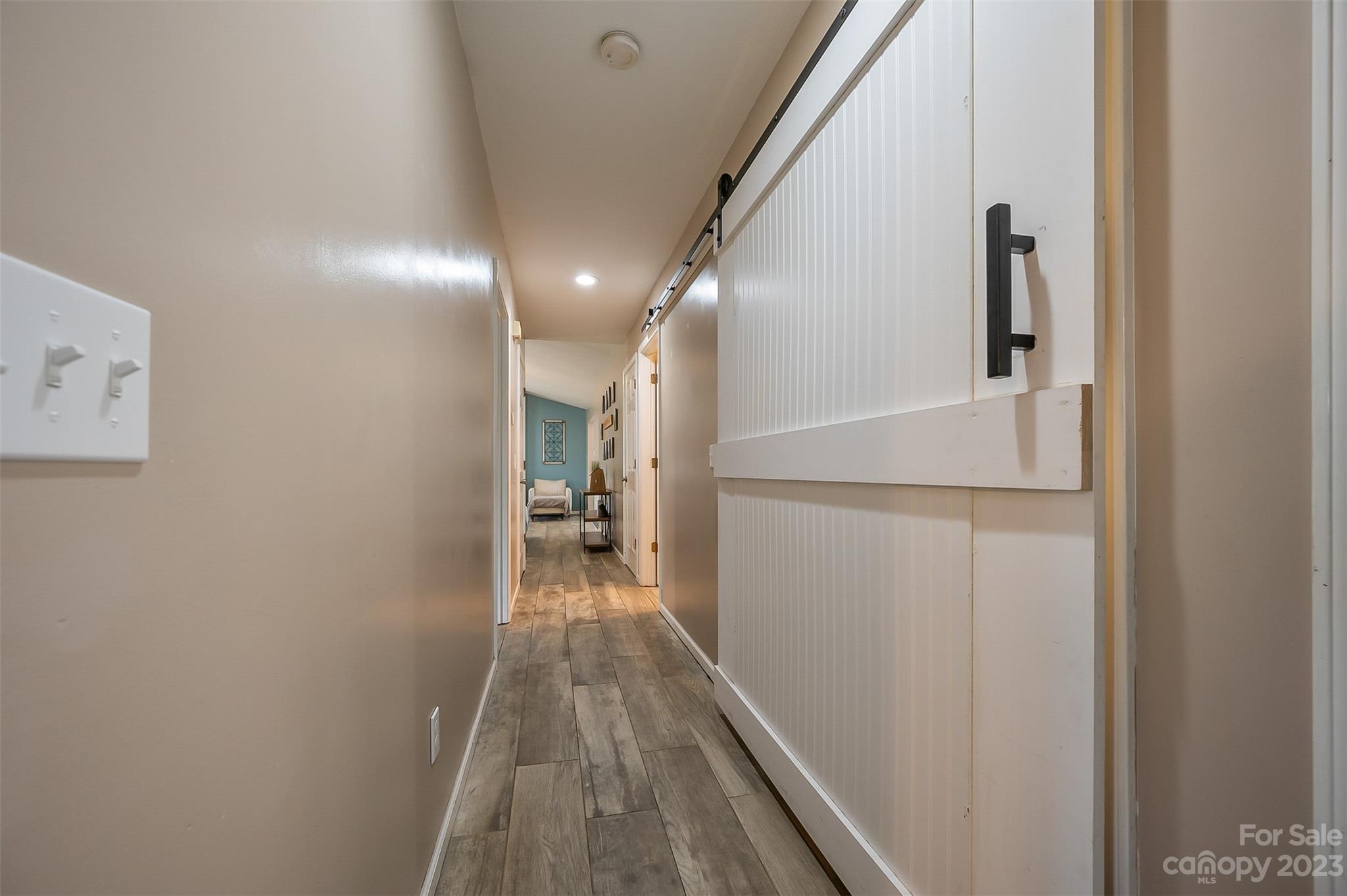 1251 Terrys Creek Road Zirconia, NC 28790 - Photo 17 of 48 a view of a hallway with wooden floor and staircase