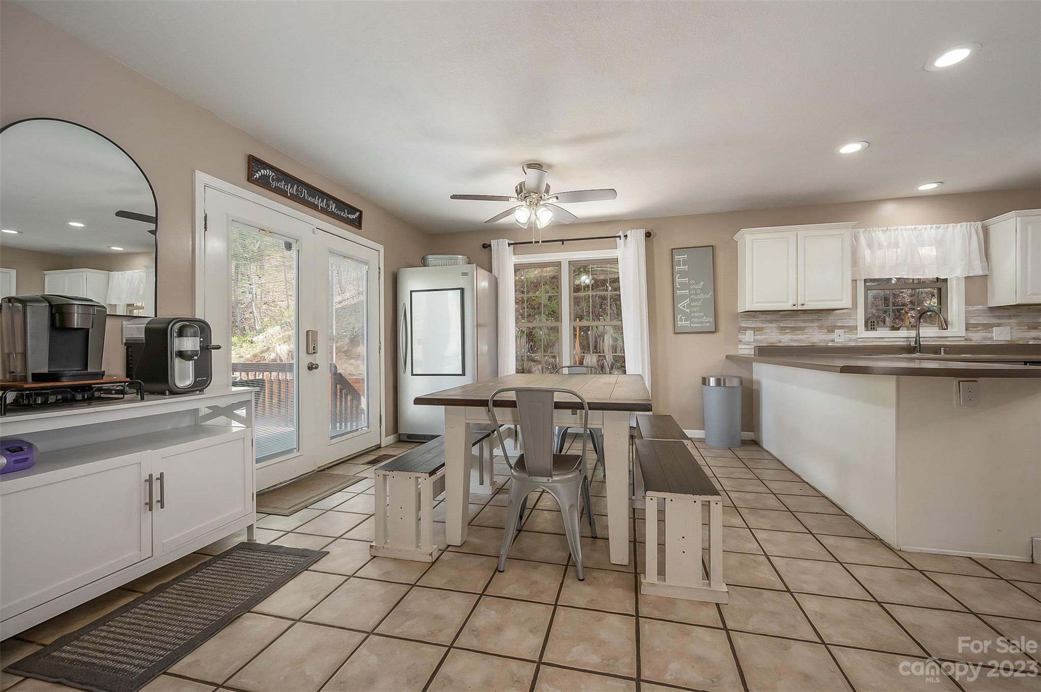 1251 Terrys Creek Road Zirconia, NC 28790 - Photo 5 of 48 a kitchen with stainless steel appliances a sink a stove a refrigerator cabinets and dining table